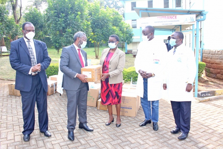The University of Nairobi Vice Chancellor, Prof. Stephen Kiama hands over personal protective kits to the School of Dental Sciences Dean Dr. Regina Mutave. Looking on are CHS Principal, Prof. James Machoki(L), Dr. Walter Odhiambo and Dr. Tom Dienya.