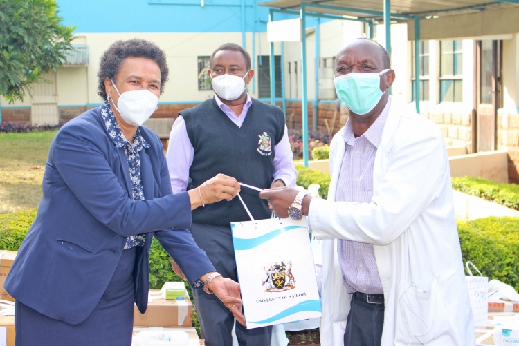 CHS Deputy Principal Prof. Evelyn Wagaiyu hands over a gift package to EAKI Director Prof. Peter Mungai.
