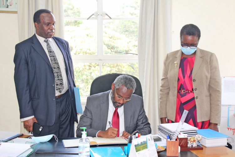 UoN Vice Chancellor Prof. Stephen Kiama signs visitors book when he visited the School of Dental Sciences Dean's Office.