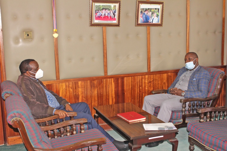 Christian Aid Country Manager Njoroge Mucheru (Right) chats with Prof. James Machoki (Left) Dean Faculty of Health Sciences during the handover of the vehicle donation.