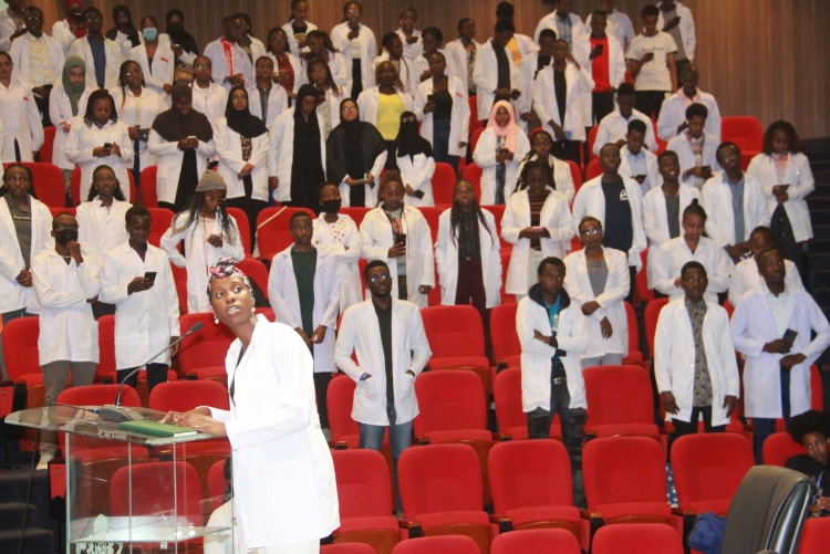 The cloaked students reciting the oath