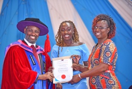 Vice Chancellor Prof. Stephen Kiama (L) awards Dau Rebbeca Adut after emerging as the best final year student.